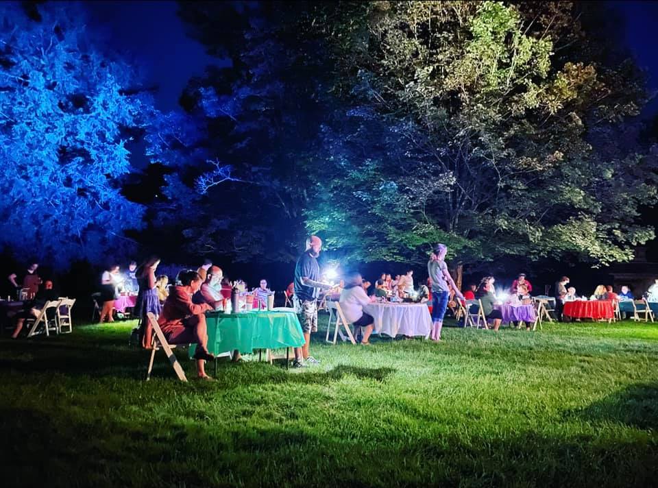 Nighttime photo of guests at a lawn party
